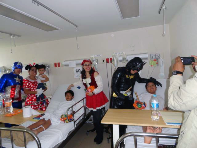 Personas caracterizadas de superhéroes con pacientes de un hospital